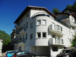 un edificio blanco con coches estacionados frente a él en Appartement Brides-les-Bains, 2 pièces, 6 personnes - FR-1-512-153, en Brides-les-Bains