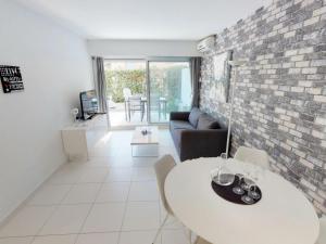 a living room with a white table and a brick wall at Appartement Menton, 2 pièces, 4 personnes - FR-1-196-164 in Menton