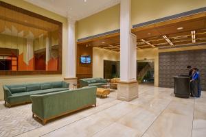 a lobby with green couches in a building at Ramee Panchshil in Kolhapur