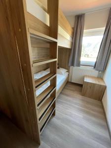 エールヴァルトにあるTiroler Alpblick Appartementsの小さな部屋(木製の棚、ベッド付)