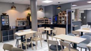 un restaurant avec des tables, des chaises et un comptoir dans l'établissement B&B HOTEL Sète Centre Gare, à Sète