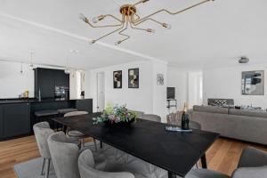 uma sala de jantar e sala de estar com uma mesa preta e cadeiras em Sanders Regent - Chic Three-Bedroom Apartment Near Central Square em Copenhague