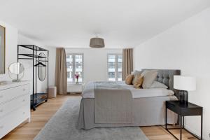 um quarto branco com uma cama grande e um candeeiro em Sanders Regent - Chic Three-Bedroom Apartment Near Central Square em Copenhague
