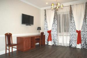 um quarto com uma secretária, uma televisão e cortinas em Hotel Karavan em Petrozavodsk