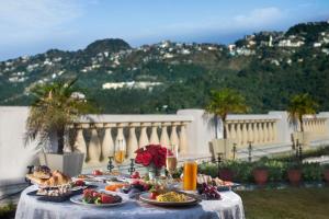 a table with plates of food and flowers on it at Jaypee Residency Manor in Mussoorie