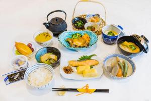 a table topped with bowls of food and other dishes at The Bridge Hotel Shinsaibashi in Osaka
