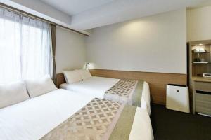 Un pat sau paturi într-o cameră la The Bridge Hotel Shinsaibashi