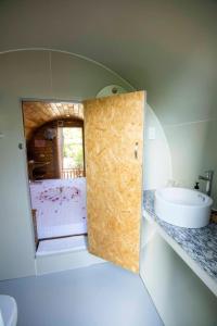 a bathroom with a door open to a bathroom with a sink at Nhà Ống Newwave Vũng Tàu - Venuestay in Vung Tau