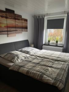 ビューズムにあるFerienwohnung Nordlichtのベッドルーム1室(ベッド1台付)、植物のある窓が備わります。