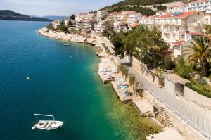 a boat in a body of water next to buildings at Hotel Villa Nova in Neum