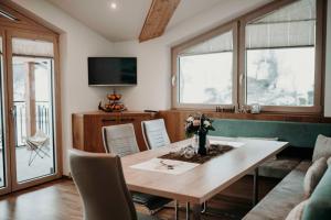 a living room with a table and chairs and a tv at Green Apart in Uderns