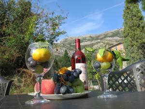 a table with two wine glasses and a bottle of wine at Apartments Victoriya in Sutomore