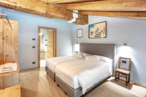 a bedroom with a large bed with a wooden ceiling at Aux Pieds du Roi - Suite & Spa in Breuil-Cervinia +37 photos