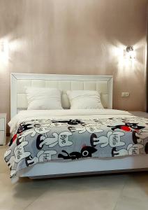 a bed with a comforter with cats on it at 1 кк люкс лофт студия in Mykolaiv