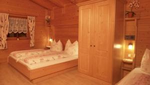 a bedroom with a bed in a wooden room at Appartement Bergrose in Hopfgarten im Brixental