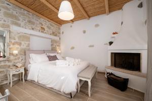 a bedroom with a bed and a fireplace at Physis Country House near Matala beach & Faistos in Kousés
