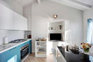 eine Küche mit weißen Wänden und blauen Schränken in der Unterkunft Old city apartment seaview in Bordighera
