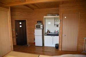 a small kitchen with a refrigerator and a microwave at Wakka in Minami Aso