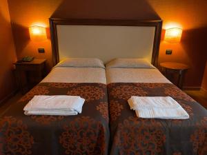1 dormitorio con 1 cama con 2 toallas en Hotel Cascina Marisa, en Opera
