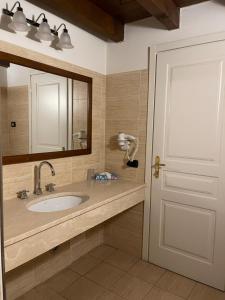 a bathroom with a sink and a mirror at Hotel Cascina Marisa in Opera