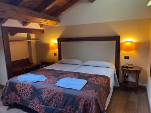 um quarto com uma cama com toalhas azuis em Hotel Cascina Marisa em Opera