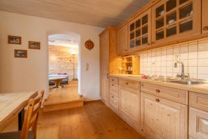 a kitchen with wooden cabinets and a wooden table at Ferienwohnung Bergluft in Mittenwald +26 photos