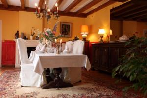 ein Esszimmer mit einem weißen Tisch mit Kerzen darauf in der Unterkunft Les Belles Dormantes in Lachaise