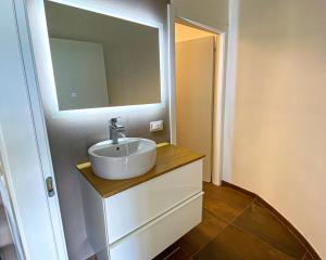 ein Bad mit einem Waschbecken und einem Spiegel in der Unterkunft Alpinlake Lodge & Wellness in Bosentino