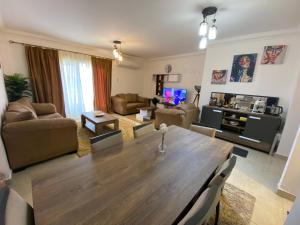 a living room with a large wooden table in a living room at Madinaty Well-furnished 3- Bedroom apartment - شقة فندقيه للايجار مدينتي in Madīnat ash Shurūq