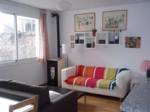 a living room with a couch with a colorful blanket at Apartamentos el Camino in Villafranca del Bierzo