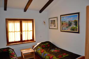 ein Wohnzimmer mit einem Sofa und einem Fenster in der Unterkunft Podrum Miljević in Ledinci