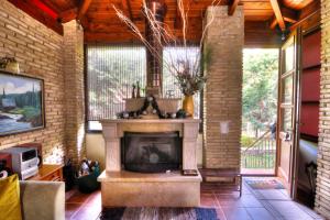 a fireplace in a living room with a brick wall at Villa Escobadd in Arachova