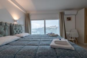 a bedroom with a large bed with a large window at Eos Sea View Apartments in Syracuse
