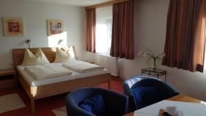 Habitación de hotel con 1 cama y 2 sillas en Hotel Garni Edelweiß, en Siegsdorf