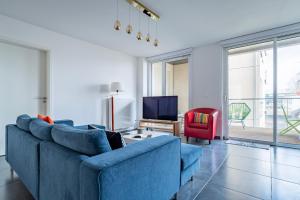 a living room with a blue couch and a red chair at L'Académie - GOLDEN TREE - Parking Privé & Wifi - 5 min centre ville de Strasbourg in Strasbourg