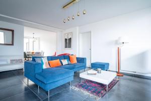 un salon avec un canapé bleu et une table dans l'établissement L'Académie - Terrasse avec vue - Parking, à Strasbourg