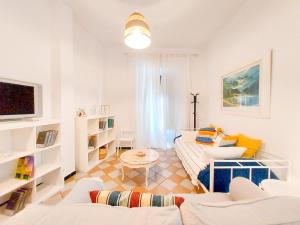 a white living room with a couch and a table at APARTAMENTO SUITE ALAMEDA-CALATRAVA. in Seville