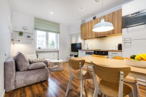 a kitchen and living room with a table and chairs at Apartamenty Black&White in Gdynia