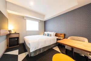 a hotel room with a bed and a table at Tokyu Stay Sapporo Odori in Sapporo