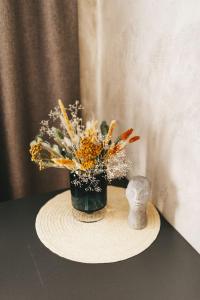 a vase of flowers and a statue on a table at NUDE Просторі апартаменти біля історичного центру вул.Збаразька in Ternopilʼ