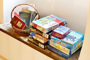 a pile of books sitting on a shelf with a basket at Quellenhof - Wohnen im Denkmal - Wohnung "QUELLE" in Blankenheim