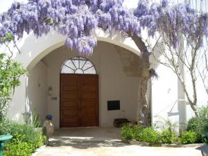 a wisteria tree in front of a door at B&B Le Due Corti in Martignano