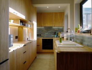 a large kitchen with wooden cabinets and a sink at Kittiwake Cottage in Scarborough