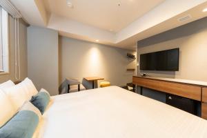 a hotel room with a bed and a flat screen tv at Tokyu Stay Sapporo Odori in Sapporo