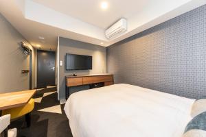 a bedroom with a bed and a desk and a tv at Tokyu Stay Sapporo Odori in Sapporo