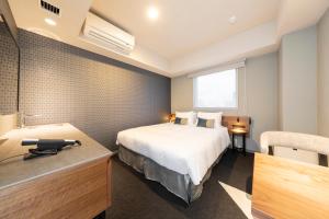 a hotel room with a bed and a desk at Tokyu Stay Sapporo Odori in Sapporo