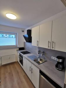 O bucătărie sau chicinetă la Frisch sanierte Ferienwohnung 2 min vom Südstrand - Balkon - PAY TV