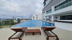 balkon z 2 krzesłami i basen w budynku w obiekcie Swan Garden Resort Hotel w Malakce