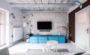 a living room with a blue table and a brick wall at Apartmán Malý princ in Dolní Lomná