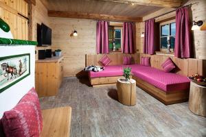 a living room with a purple bed in a cabin at Ettlerlehen Chalets in Ramsau